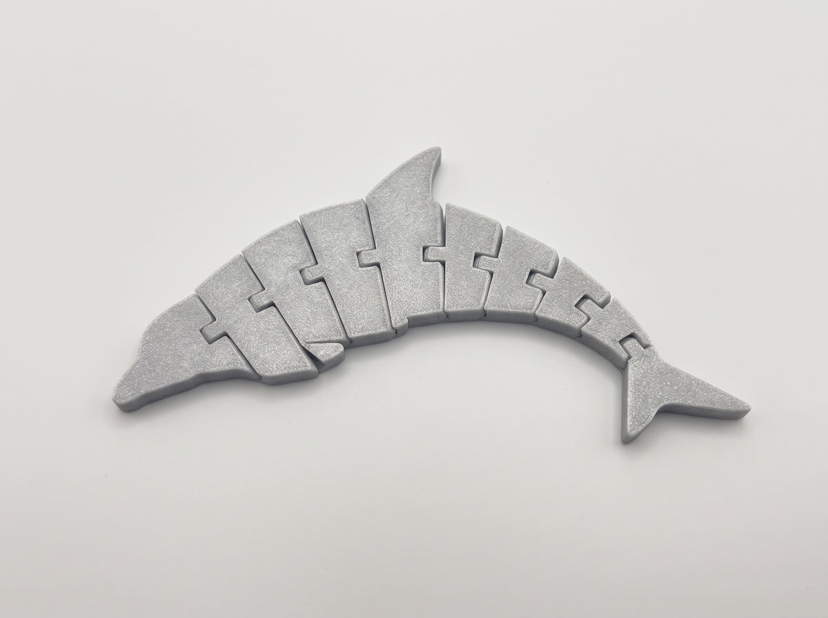 Gray articulated dolphin with a segmented body curved on a light background