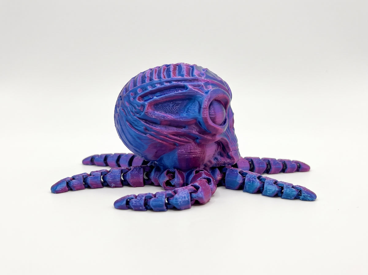 Side view of the articulated octo-alien showing its ridged alien head and jointed blue and purple tentacles.